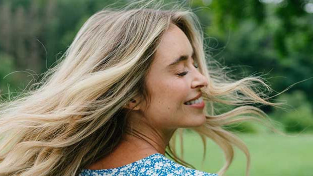 Blonde Frau mit schönen langen Haaren in der Natur