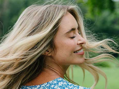 Blonde Frau mit schönen langen Haaren in der Natur
