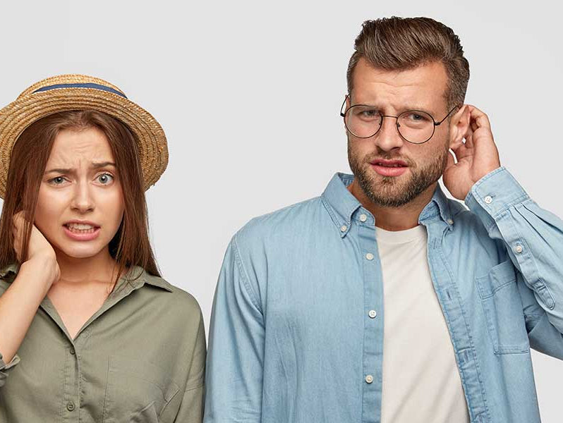 Paar schaut fragend in die Kamera: Sind Schuppen ansteckend?