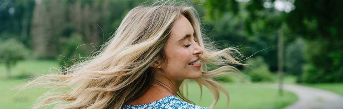 Blonde Frau mit schönen langen Haaren in der Natur